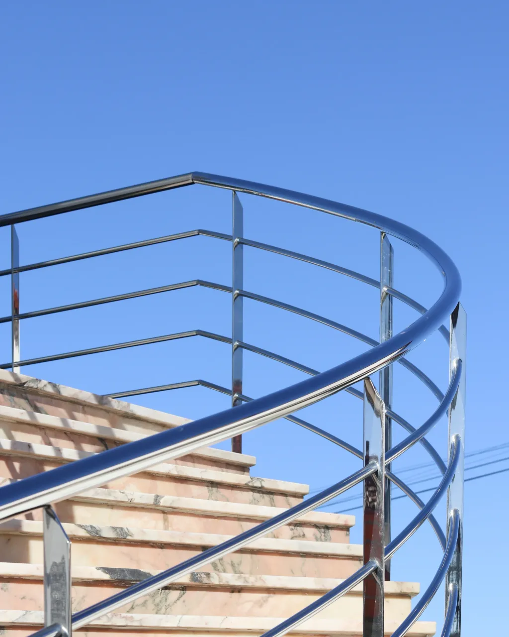 Corrimão curvo em aço inox numa escada exterior